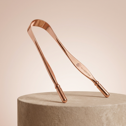 Nuvaressa Copper Tongue Scraper on a stone pedestal