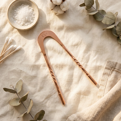 Nuvaressa Copper Tongue Scraper flat-lay on cream linen